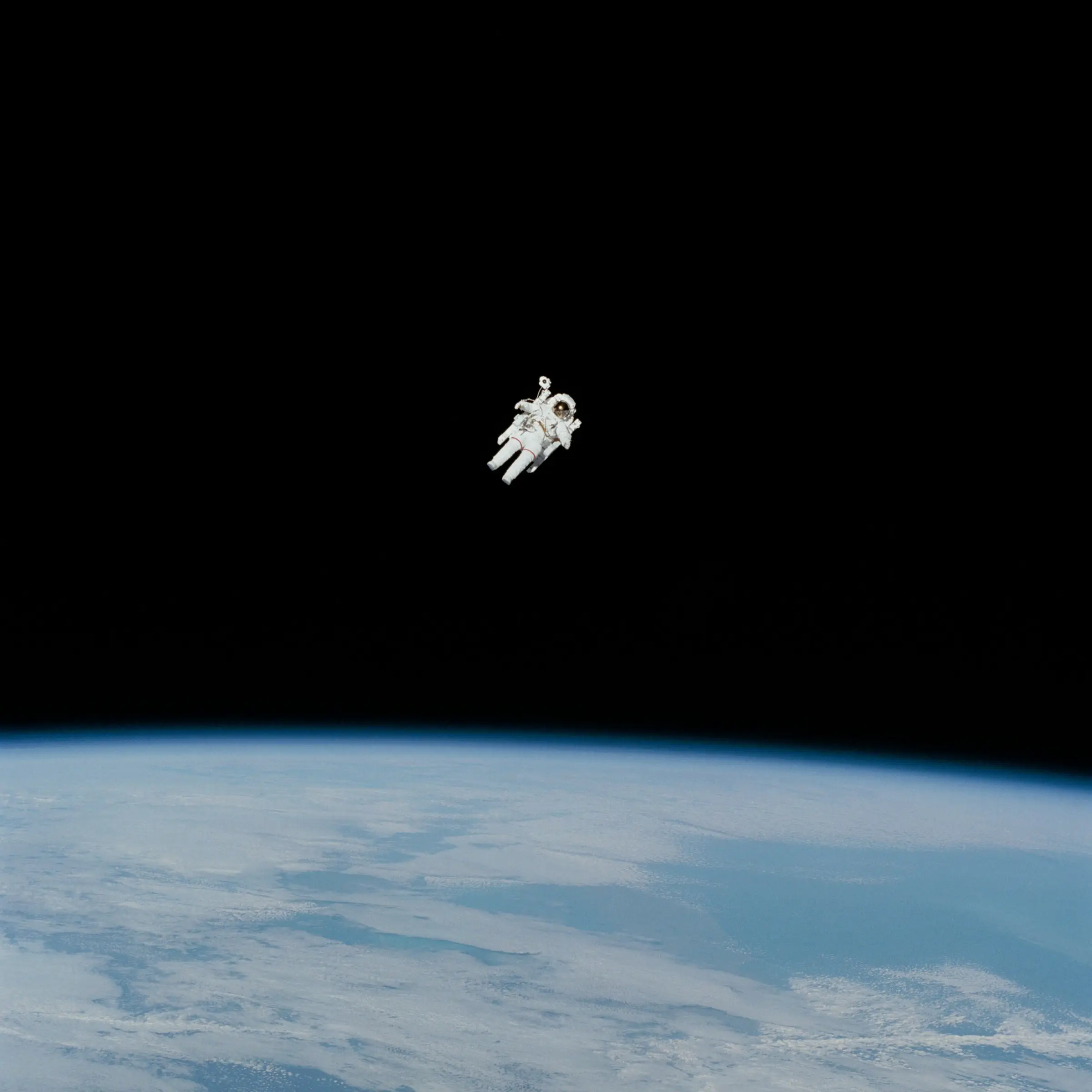 An astronaut in free flight above Earth's blue horizon