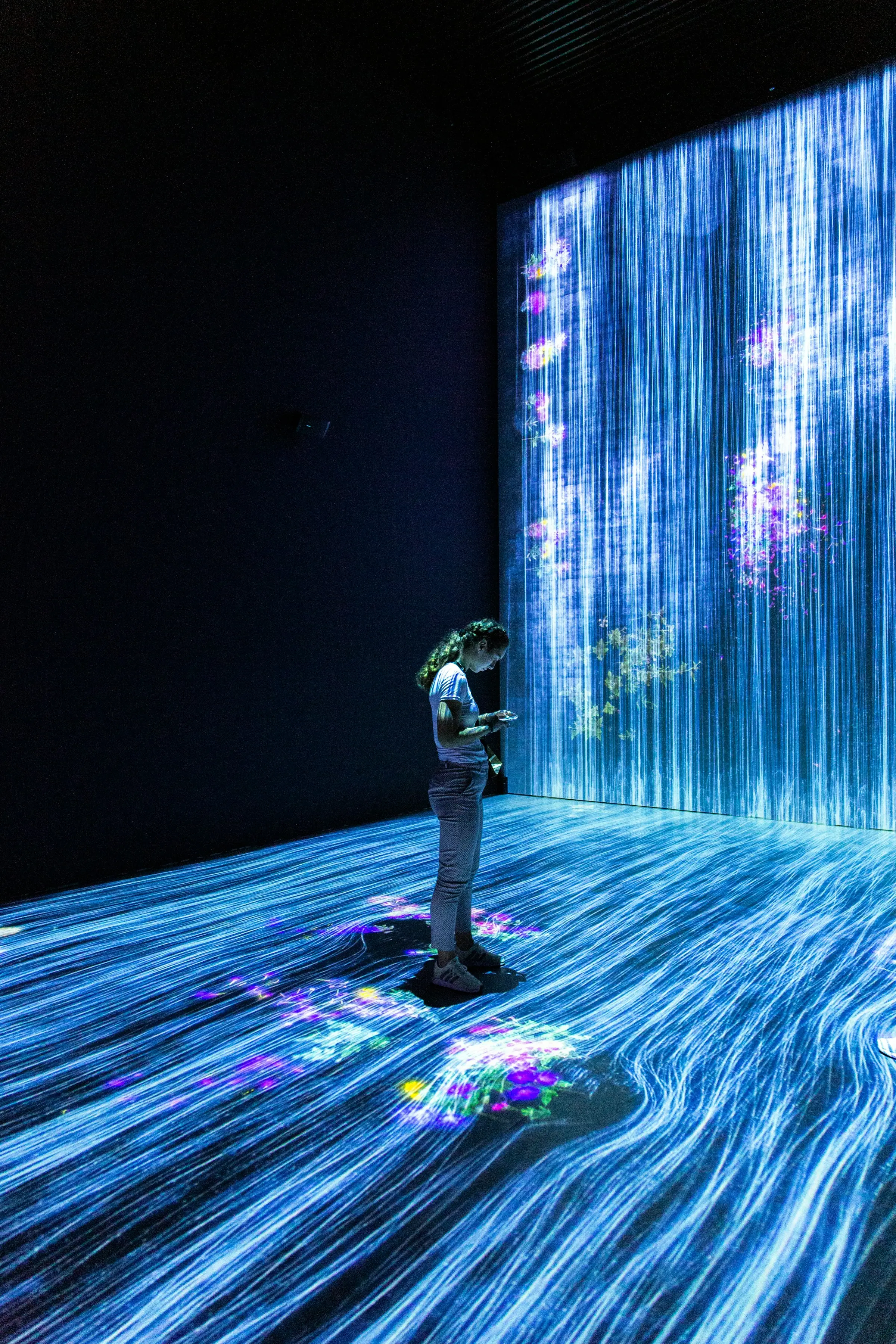 A visitor standing inside an immersive projected light installation