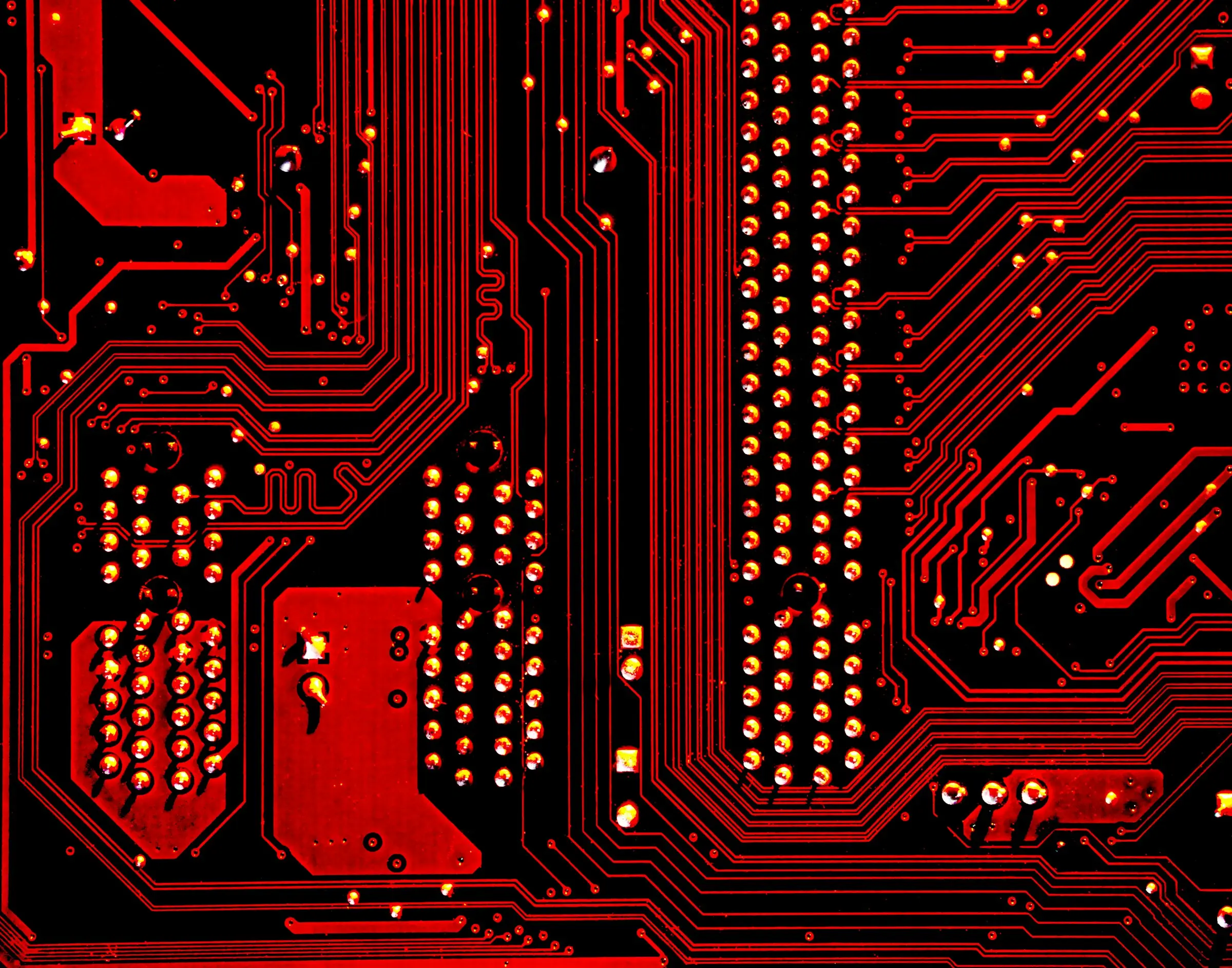 Macro photograph of copper traces on a red circuit board