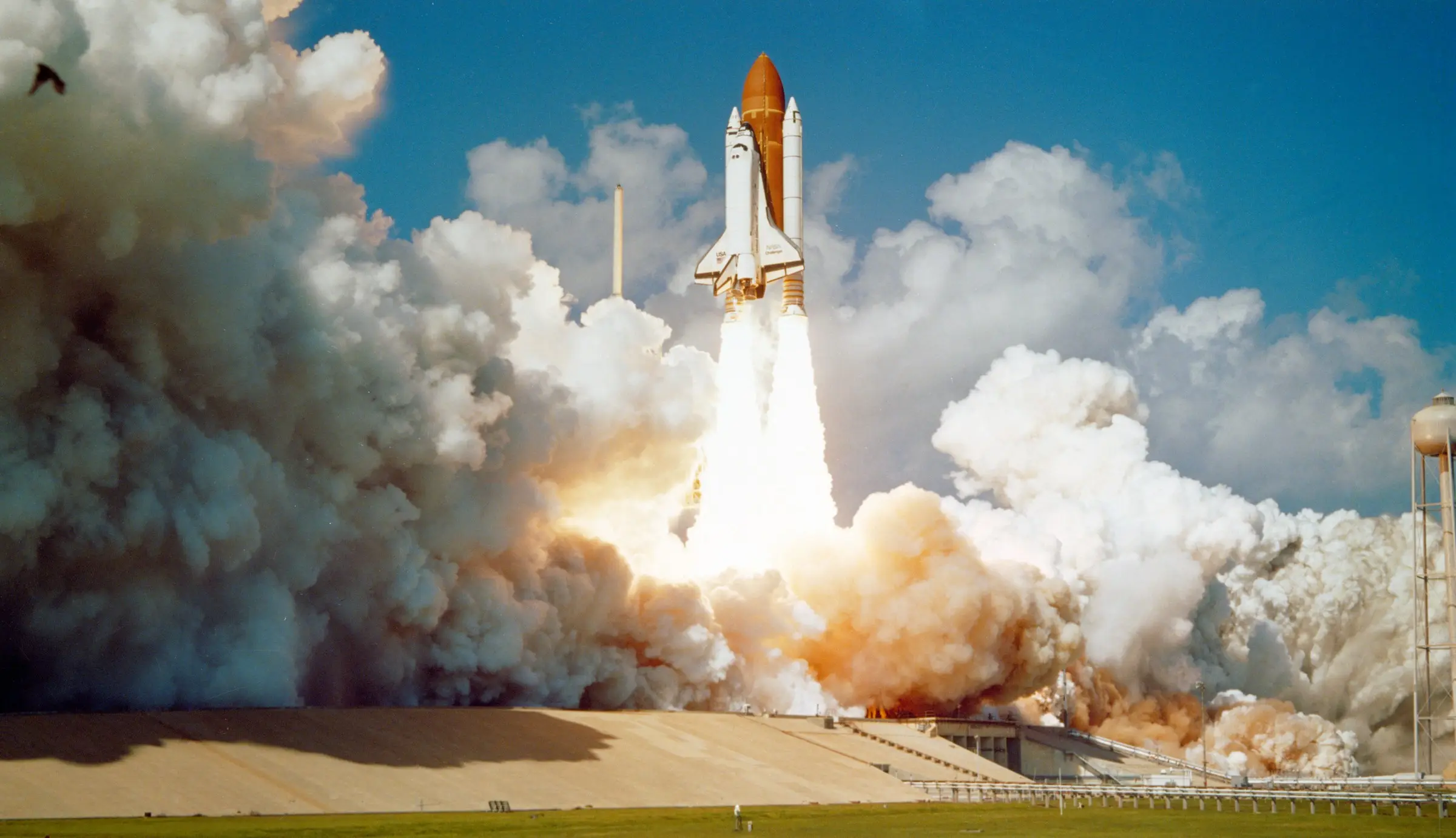 A spacecraft lifting off through its own exhaust clouds